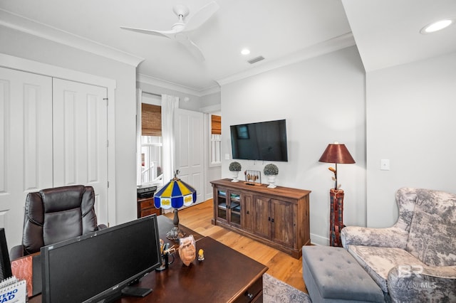 living room featuring ceiling fan, light hardwood / wood-style floors, and ornamental molding