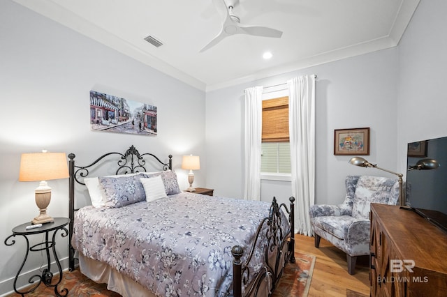 bedroom featuring ceiling fan, light hardwood / wood-style flooring, and crown molding