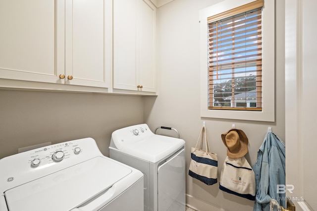 washroom featuring cabinets and washer and clothes dryer