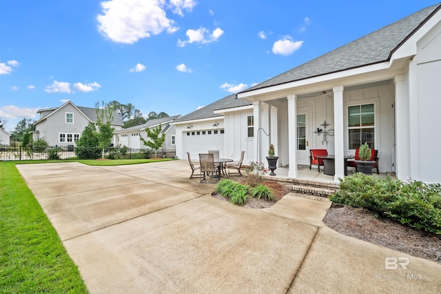 view of front of property featuring a patio, a porch, and a garage