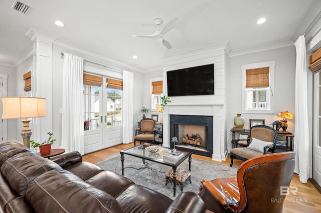 living room with ceiling fan, light hardwood / wood-style floors, and ornamental molding