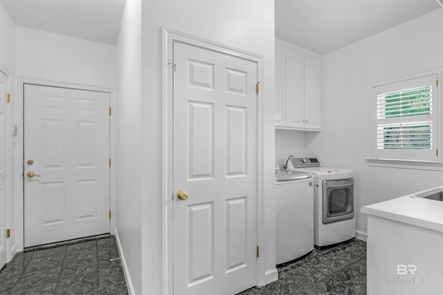 clothes washing area featuring cabinets and washing machine and clothes dryer