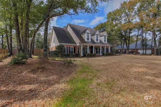 new england style home with covered porch and a front yard