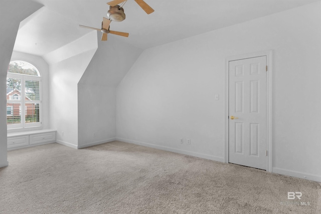 additional living space featuring vaulted ceiling, light colored carpet, and ceiling fan