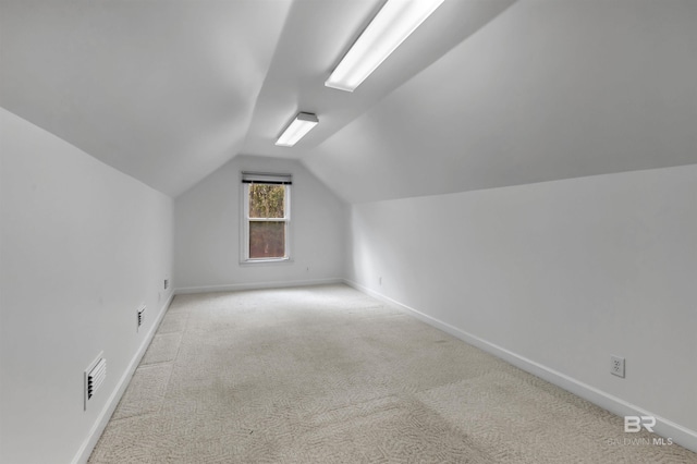 additional living space with light colored carpet and lofted ceiling