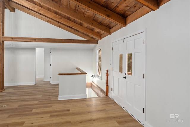 entryway with vaulted ceiling with beams, light hardwood / wood-style floors, and wood ceiling