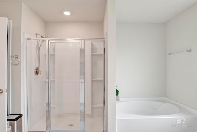 bathroom featuring shower with separate bathtub