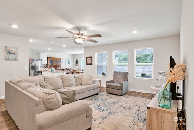 living room with light wood-type flooring and ceiling fan