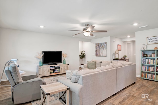 living room with ceiling fan and light hardwood / wood-style flooring