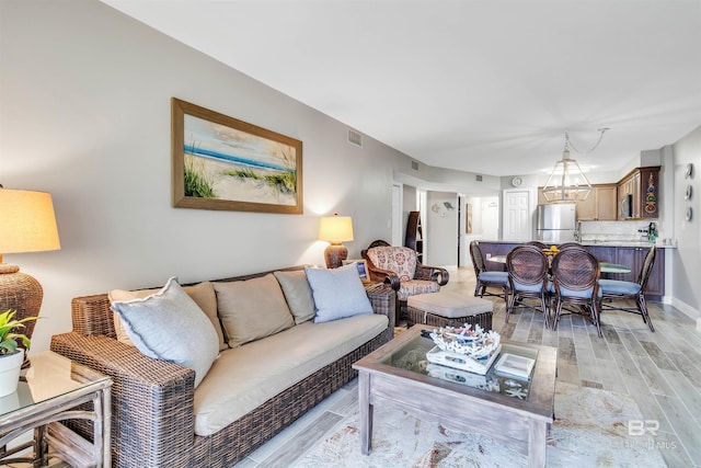 living room featuring an inviting chandelier and light hardwood / wood-style floors