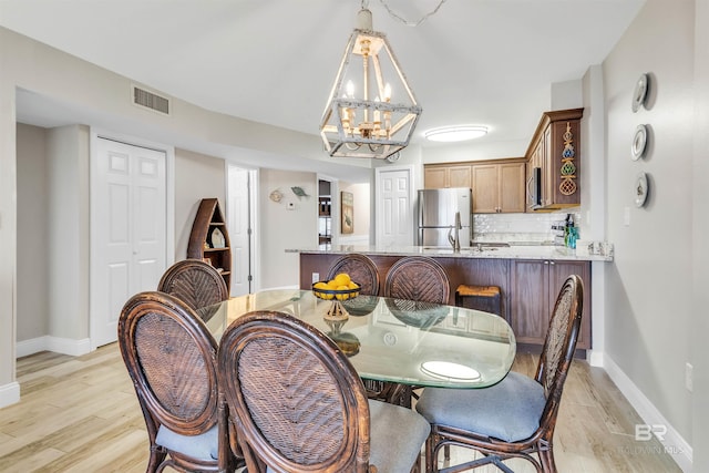 dining room featuring light hardwood / wood-style floors and an inviting chandelier