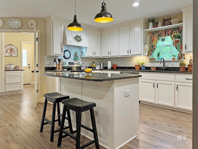 kitchen with sink, light wood-type flooring, a center island, custom exhaust hood, and white cabinets