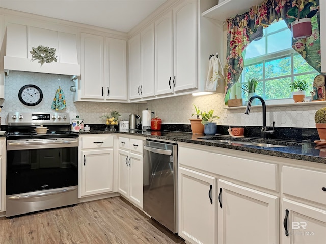 kitchen featuring sink, appliances with stainless steel finishes, white cabinets, and dark stone countertops