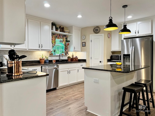 kitchen featuring white cabinetry, light hardwood / wood-style floors, appliances with stainless steel finishes, and a center island