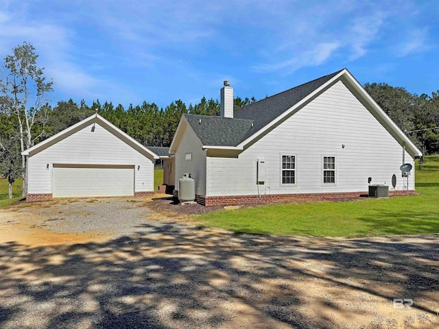 view of side of home featuring a yard, central air condition unit, and a garage