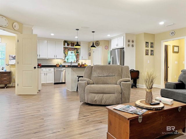 living room with sink and light wood-type flooring