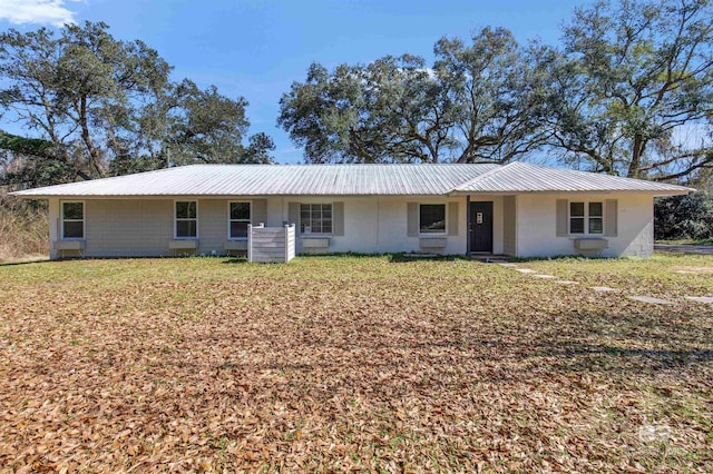 ranch-style home with metal roof and a front yard