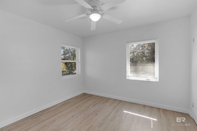 spare room with ceiling fan, plenty of natural light, baseboards, and light wood-style flooring