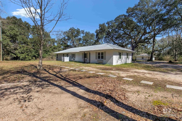 view of front of home featuring driveway and metal roof