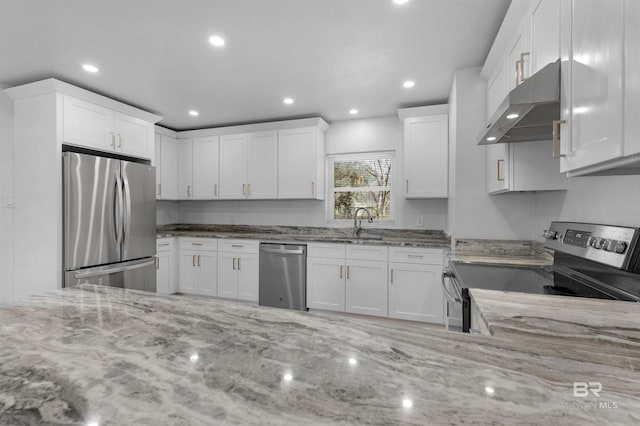 kitchen featuring light stone counters, appliances with stainless steel finishes, white cabinetry, and under cabinet range hood