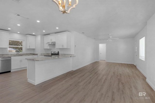 kitchen featuring under cabinet range hood, stainless steel appliances, a sink, white cabinetry, and open floor plan