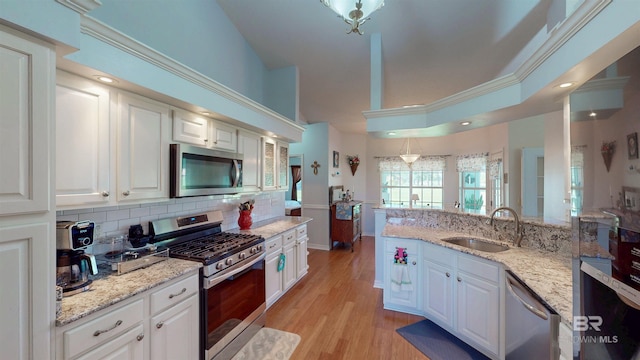 22355 County Road 12, Foley, AL 36535 - kitchen with stainless steel appliances, a sink, white cabinets, tasteful backsplash, and ornamental molding