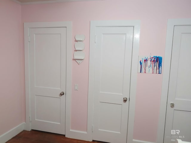 hall with crown molding and dark wood-type flooring