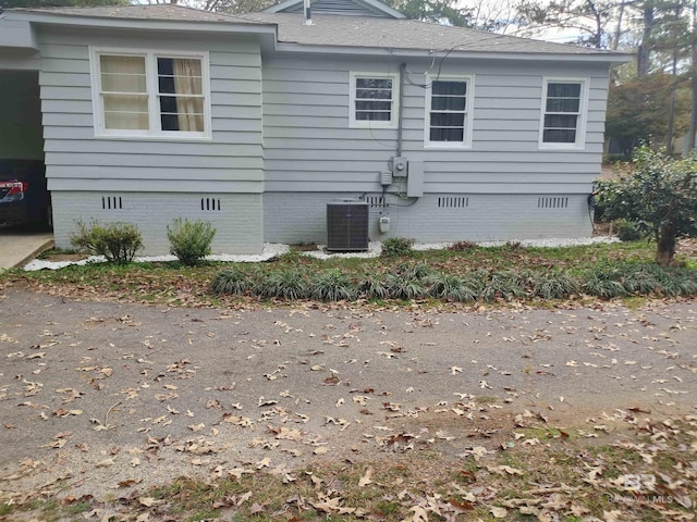 view of side of home with central AC unit