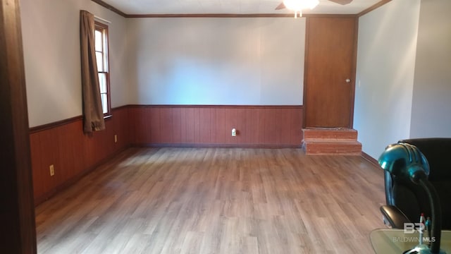 spare room featuring light hardwood / wood-style flooring, ceiling fan, and ornamental molding