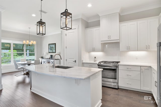 kitchen with pendant lighting, stainless steel range with gas stovetop, a sink, white cabinetry, and an island with sink