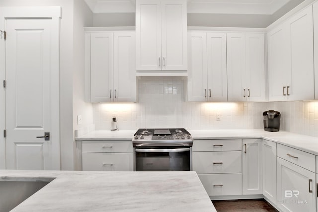 kitchen with gas stove, white cabinetry, and tasteful backsplash