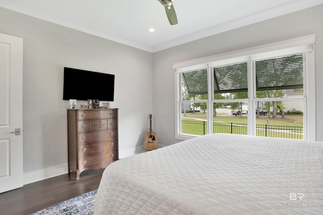 bedroom featuring dark wood-type flooring, multiple windows, a ceiling fan, and crown molding