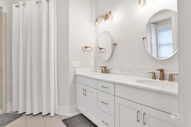 full bathroom featuring double vanity, a sink, baseboards, and tile patterned floors