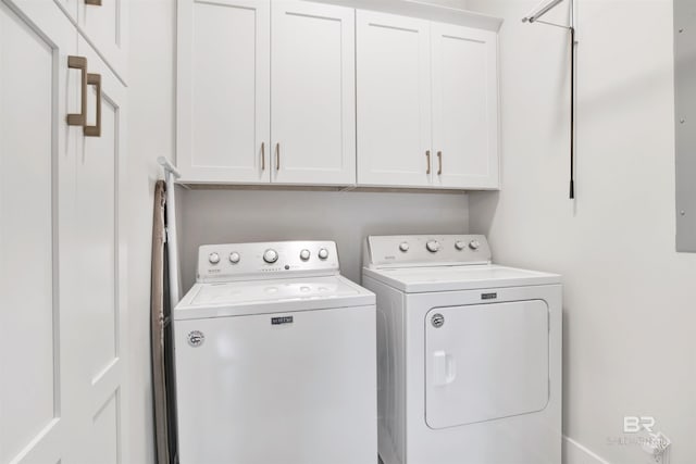 clothes washing area featuring cabinets and washing machine and dryer