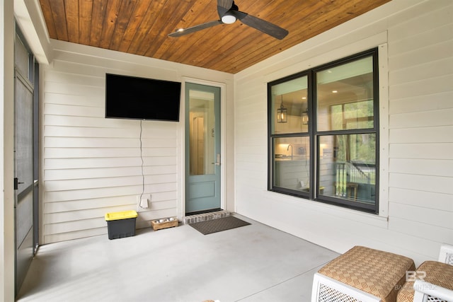 view of exterior entry featuring a patio area and a ceiling fan