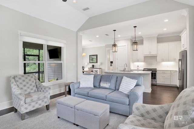 living room with light hardwood / wood-style flooring, vaulted ceiling, and sink