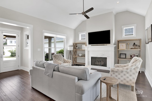 living room featuring lofted ceiling, dark wood-style floors, and a premium fireplace