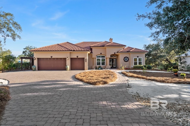 mediterranean / spanish home featuring a garage