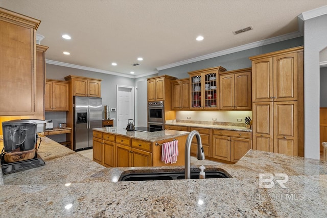 kitchen with light stone countertops, sink, ornamental molding, and stainless steel appliances