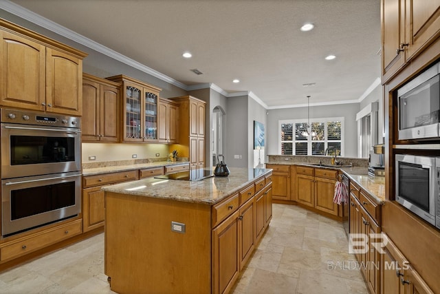 kitchen with light stone counters, stainless steel appliances, crown molding, decorative light fixtures, and a kitchen island