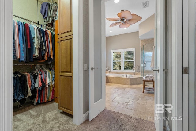 walk in closet with ceiling fan