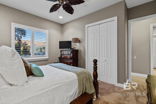 carpeted bedroom featuring ceiling fan and a closet