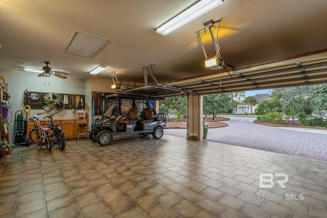 garage with a garage door opener and ceiling fan