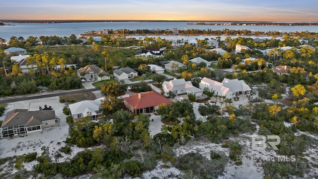 aerial view at dusk featuring a water view