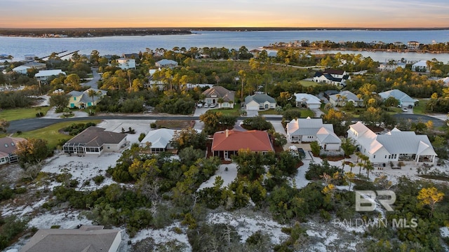 aerial view at dusk featuring a water view