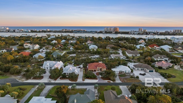 aerial view at dusk featuring a water view