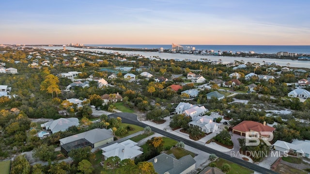 aerial view at dusk featuring a water view