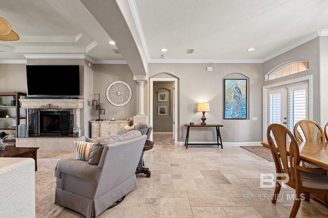 living room with ornate columns, crown molding, a premium fireplace, and a textured ceiling