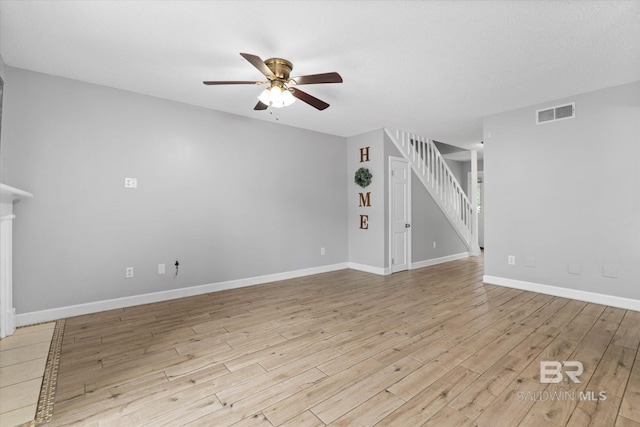 6701 Dickens Ferry Rd Unit 40, Mobile, AL 36608 - unfurnished living room featuring a ceiling fan, light wood-type flooring, stairs, and baseboards