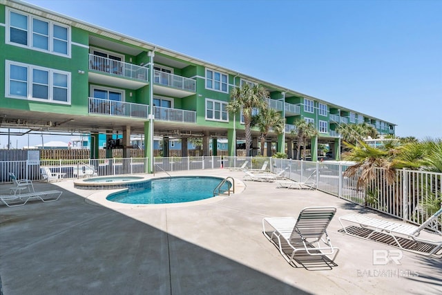 view of pool featuring a community hot tub and a patio